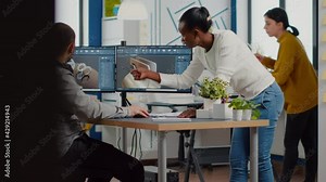 Professional heavy industry team of engineers working on computer with two monitors using CAD software with integrated development environment to design industrial machinery component.