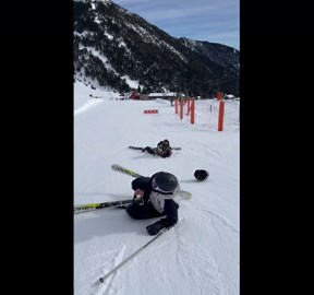 Two skiers attempt a trick but fall hilariously on a snowy hill