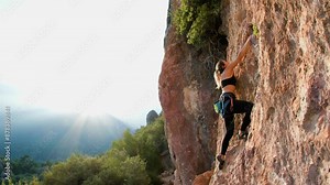 rock climber girl. A girl climbs a rock, a sporty girl is rock climbing. extreme sport, rock climbing as an Olympic sport.