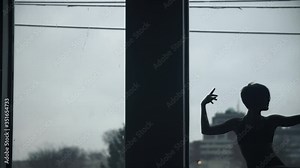 Dancer leans against window in a modern dance studio, leaning back