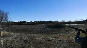 The plate flies out from under the frame. The hunter aims and falls on the plate. Stand shooting. Skeet shooting. Slow motion.