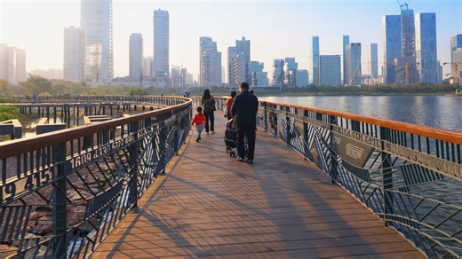 People cross pedestrian bridge by Lake China