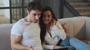 Happy couple chatting on skype at laptop computer at home together | Premium Stock Video Footage