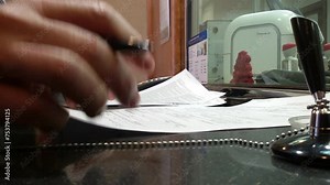 Close-up of a man in a bank signs a contract.
