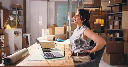 Frustrated, woman and back pain in office with laptop for ecommerce backlog, logistics fail or crisis. Computer, exhausted person and spinal injury with bad posture, supplier issue and courier delay.