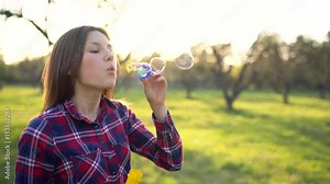 Woman blowing soap bubbles outdoors