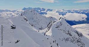 Aerial footage of the iconic freeride paradise of Verbier on a stunning bluebird day. Snow-covered peaks, wide open faces, and legendary off-piste terrain under clear alpine skies.