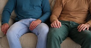 Gay man touching leg of boyfriend