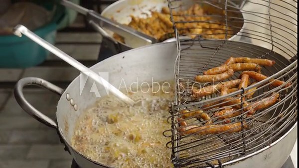 Traditional Bolivian street food, woman cooks typical sausages from Tarata, Cochabamba, frying in a frying pan full of oil.