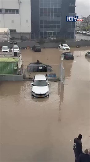 Storm Byron swept across Israel on Thursday with heavy rain and strong winds, triggering major flooding, widespread damage, and at least one death. Emergency crews rescued at least 14 drivers trapped in submerged vehicles in Yavne, where the municipality declared an emergency after multiple hotspots flooded. A Rami Levy supermarket was forced to close due to water damage, two students in Rishon Lezion were lightly injured by a falling tree, and a 53-year-old man in Netanya was found dead with si