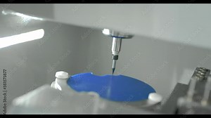 rofessional CNC dental milling machine carving out shape of artificial teeth in the dental lab. One of the steps in making of artificial teeth by dental technician in the clinic.