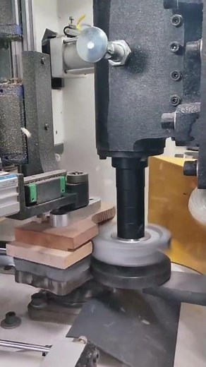 scraping the edges of a wooden box board by tracing the shape of guitar with a special machine tool