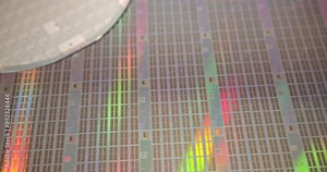 A close-up view of a silicon wafer's microprocessor circuit layout. The semiconductors or central processing unit CPU microchips are fabricated from a silicon wafer with patterned layers of materials.