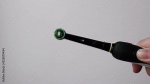 Squeezing and applying toothpaste on electric toothpaste with a winged plan on a white background. Concept: oral care, electric toothpaste, caries, hygiene. Taking care health. Toothpaste. No people