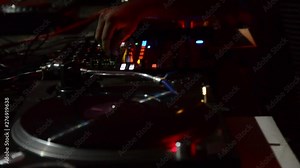 DJ working with his equipment on music festival. Professional DJ turntable records player and sound mixer. Disc jockey mixing sounds, audio and songs in nightclub.DJ scratching a record on music event