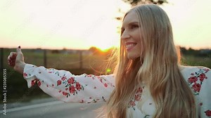 A woman traveler, WALKING ON THE ROAD. Tired young woman backpacker, starting a journey on a sunlit country road.