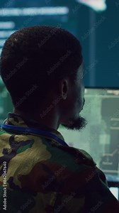 Vertical Video Army officer develops contingency plans to address unexpected developments in the field, studying real time satellite intelligence in military command post. Soldier tracking enemy