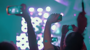 Music fans making videos with cells at the concert