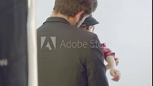 Man helps female model to adjust clothes during photoshoot