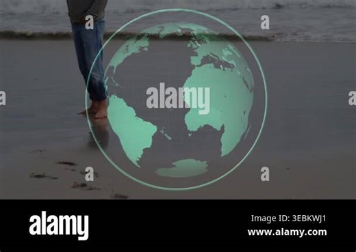 Man walking wet shore leaving prints, pausing and turning while globe overlay rotating, for travel. Barefoot, beach, ocean, overcast, reflective, orb, journey Stock Video Footage - Alamy