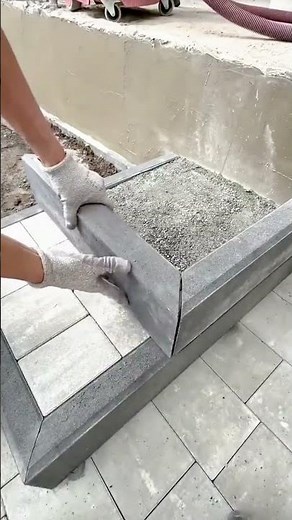 Worker Carefully Installing Concrete Edge Blocks for Garden or Pathway Border Construction