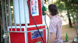 Man use gas pump nozzle filling gasoline fuel to tank of motorcycle in oil station. Thailand. 1920x1080