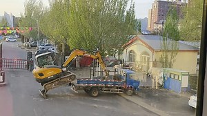 Excavator skillfully climbs onto truck in Beijing, China
