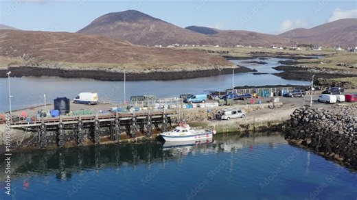 Drone shot of the Isle of Harris hills behind Leverburgh pier and harbour.