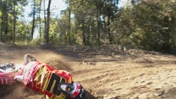 Motocross rider turning corner, sliding falling off bike. Slow Motion.