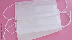 disposable masks, earloop type on soft pink surface, slowly movement