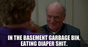 In the basement garbage bin, eating diaper shit.