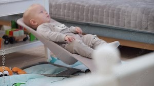 Small home security camera is installed in living room, parents uses indoor security camera as baby monitor watching their kid. Rack focus. High quality 4k footage