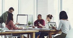 Trendy business people working on computer while planning marketing strategy for a team digital or online project. Diverse colleagues collaborating on a UI website design in the creative department
