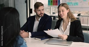 Group of teammates collaborate, gather in office, listen to colleague express opinion, share solution. Job interview process, female applicant answers questions at formal meeting with two HR managers