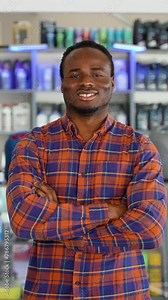 Portrait of african american salesman in an auto parts store. The concept of car repair. Vertical video