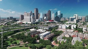 Fly to downtown Dallas skyline over uptown under blue sky