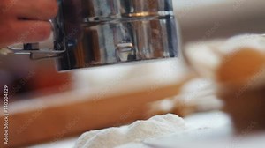 Sifting flour through sieve. Women hands sifting flour on a table. Cooking and backing preparation.