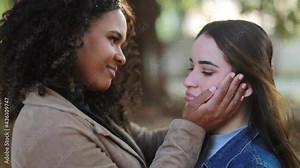 Two young women hugging in support and empathy together, two diverse people