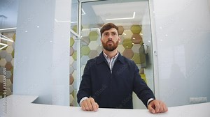 Bearded handsome man receptionist standing and using virtual augmented interface with clinic main services and pricing. Innovation in medicine. Technologies. Reception.