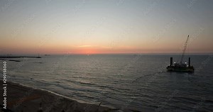 Time laps of the beach of Ashkelon Israel, at sunset, drilling rig in the sea