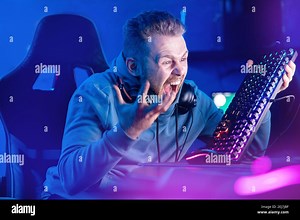 Streamer Angry computer gamer man yells and breaks keyboard after being defeated in online video game Stock Photo - Alamy