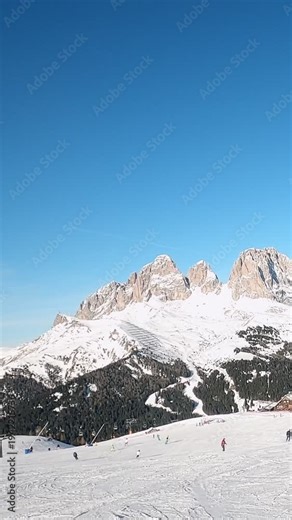 First-person view FPV first-person point of view POV of alpine skiing in Dolomites. Ski resort piste with people skiing in Dolomites in Italy. Ski area Belvedere. Canazei, Italy