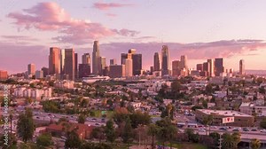 Aerial time lapse or hyperlapse of downtown Los Angeles, California skyline, skyscrapers and tall buildings from above on a sunny day during golden hour before sunset.