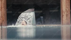 Young girl playing and swimming in an outdoor pool in winter.