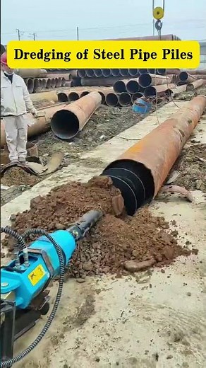 Excavator augers are used for dredging operations on steel pipe piles.