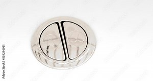 Top view of a person using a Water-Saving Dual-Flush Toilet with two flush buttons or a two-stage lever.