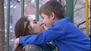 Son and mom kissing. Mother kiss her son outdoor