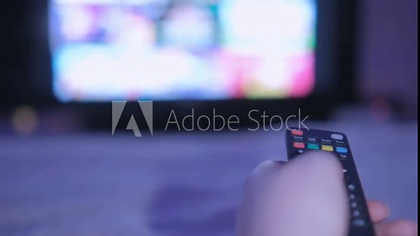 4K men hand holding the TV remote control and turn off smart tv. Channel surfing, focused on the hand and remote control. Internet TV at living room on holiday on sofa