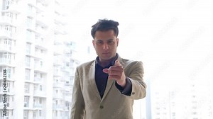 Angry boss turns and points an accusing finger right at the camera and returns