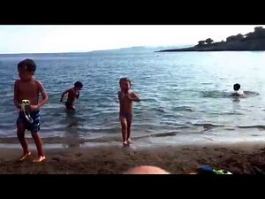 Kinder spielen beim Wasser.